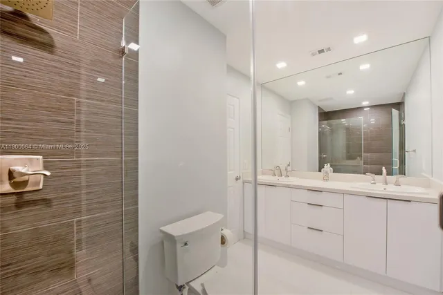 a bathroom with a double vanity sink a toilet and a mirror