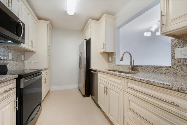 a kitchen with stainless steel appliances granite countertop a sink and a stove top oven