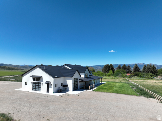 100 Whit Lane Georgetown, ID 83239 - Photo 69 of 76 View of front of home with a view of countryside, a mountain view, board and batten siding, a metal roof, and driveway