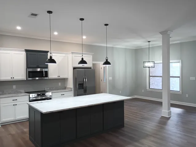 a kitchen with stainless steel appliances kitchen island a sink dishwasher a refrigerator and a flat screen tv