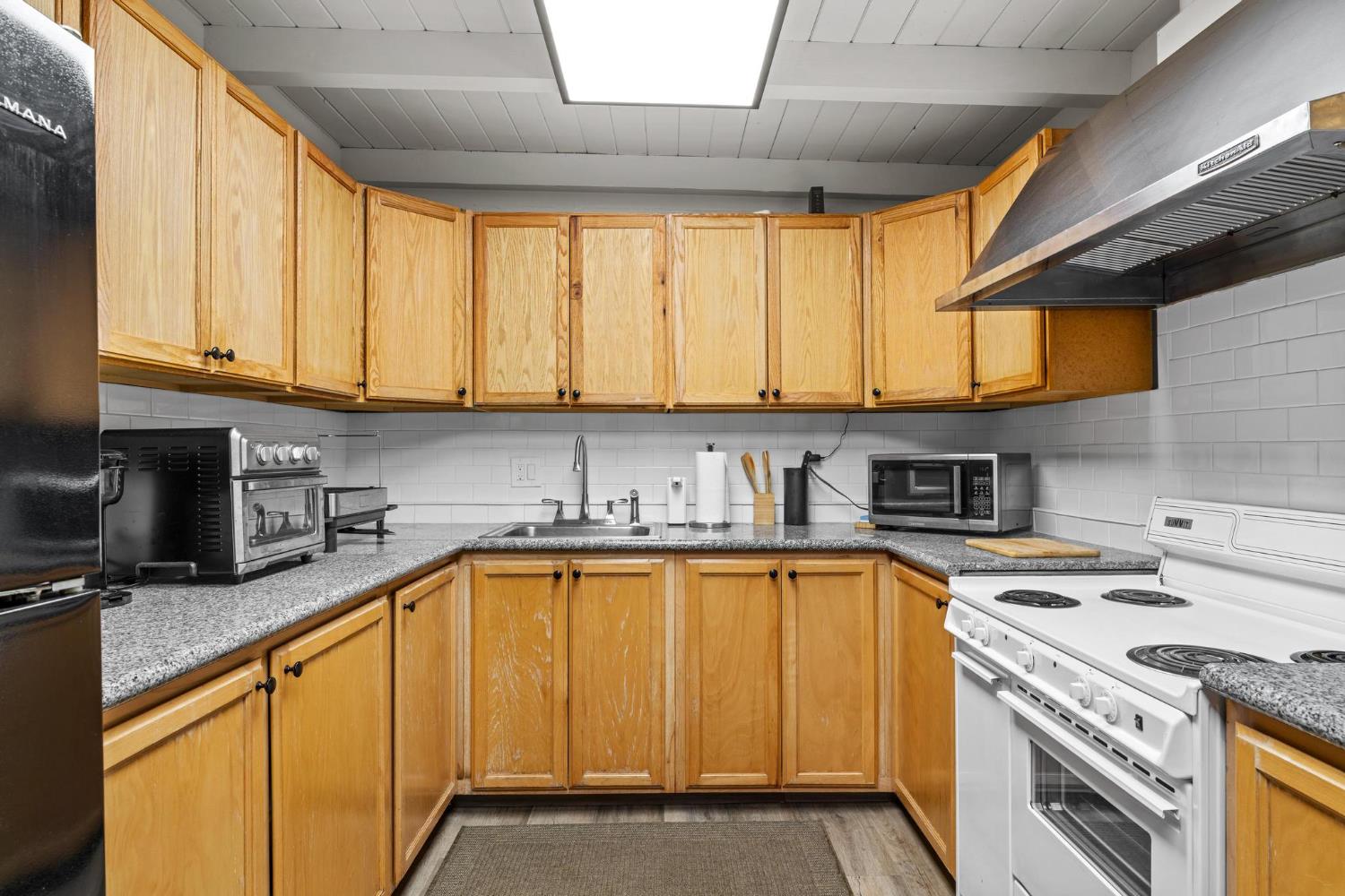 1432 Page Court Modesto, CA 95354 - Photo 11 of 62 a kitchen with stainless steel appliances granite countertop a sink a stove and a microwave