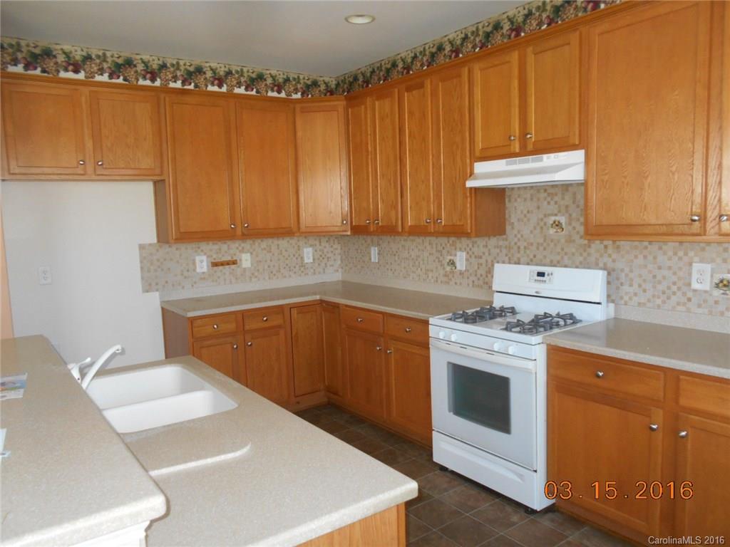 294 Garnet Court, Unit 520 Fort Mill, SC 29708 - Photo 4 of 13 a kitchen with granite countertop a sink stove and cabinets