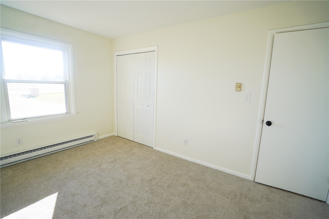 8746 Grubbs-Rex Road Arcanum, OH 45304 - Photo 5 of 38 This bright bedroom features soft carpeting, a large window, and ample closet space.