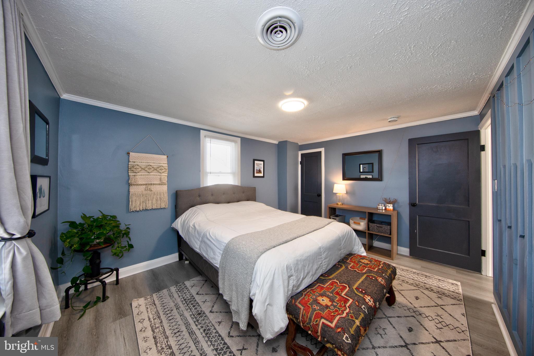 109 Elinor Avenue Nottingham, MD 21236 - Photo 16 of 33 a bedroom with a large bed and a potted plant