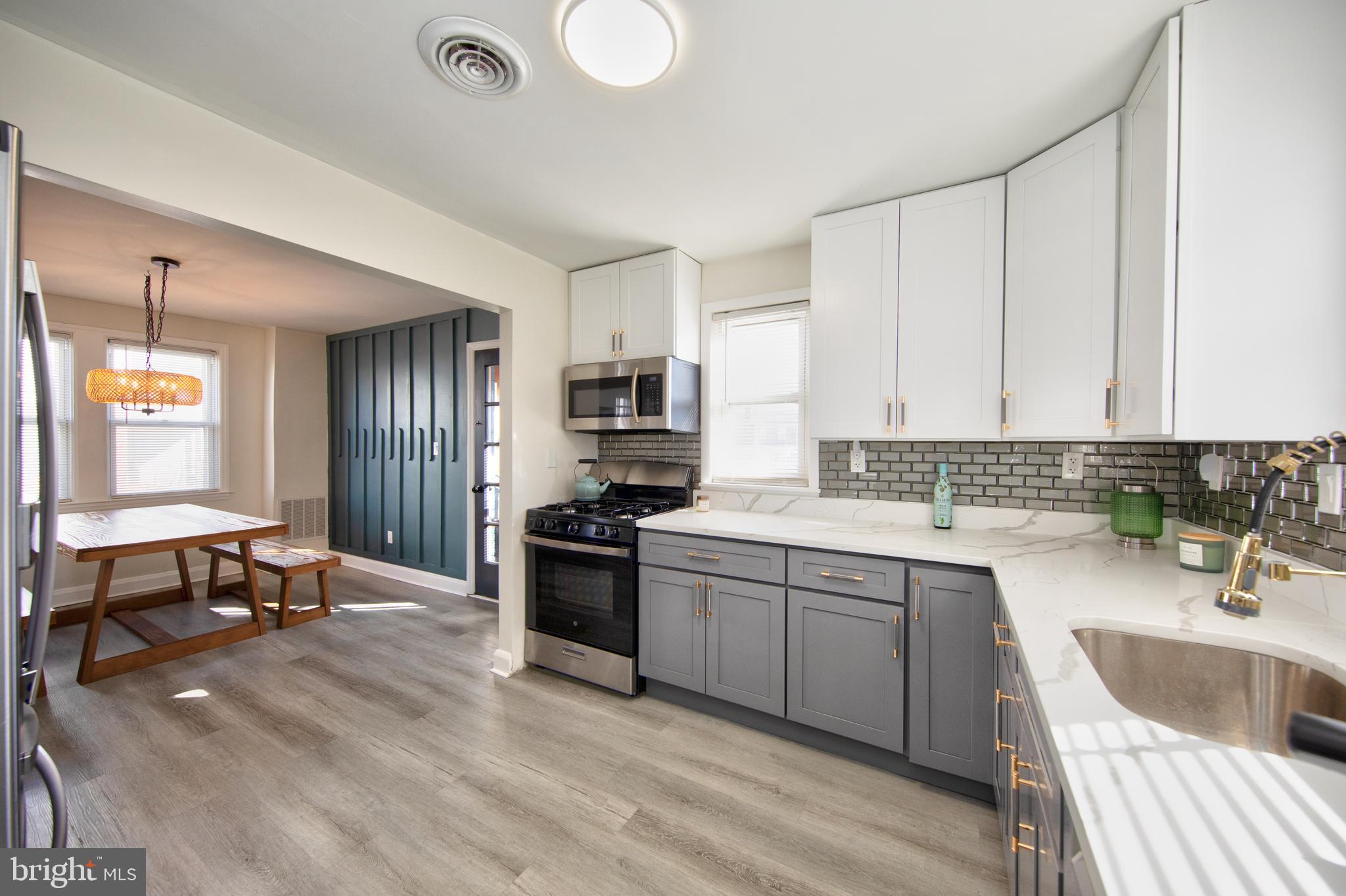 109 Elinor Avenue Nottingham, MD 21236 - Photo 10 of 33 a kitchen with a sink dishwasher a stove and a refrigerator with wooden floor