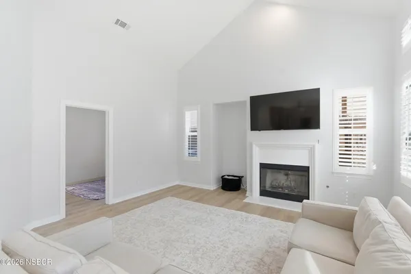 a living room with furniture a flat screen tv and a fireplace