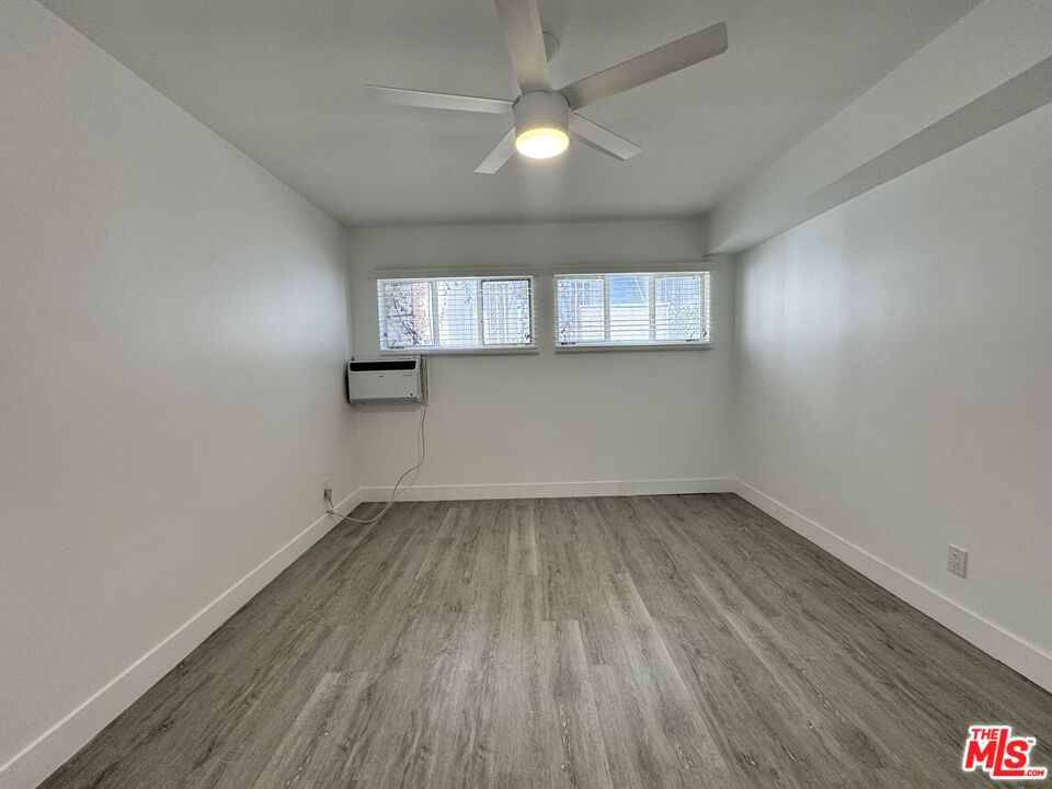 1279 North Harper Avenue, Unit 5A West Hollywood, CA 90046 - Photo 15 of 16 an empty room with wooden floor and windows