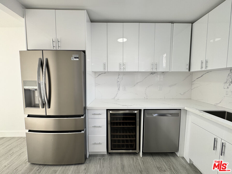 1279 North Harper Avenue, Unit 5A West Hollywood, CA 90046 - Photo 7 of 16 a kitchen with cabinets and stainless steel appliances
