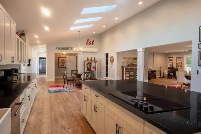 a large kitchen with lots of counter top space a sink and stainless steel appliances