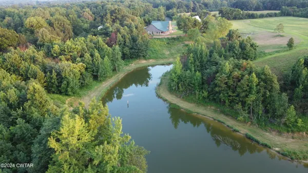an aerial view of residential houses with outdoor space and lake view