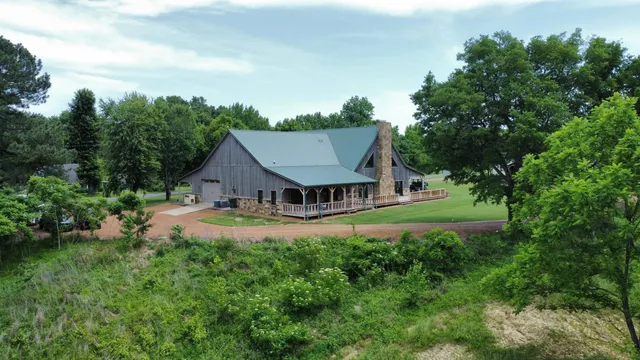 a view of a house with a big yard and large trees