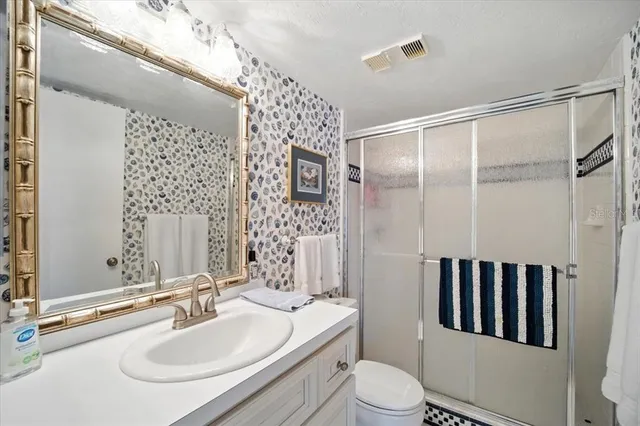 a bathroom with a double vanity sink toilet and shower