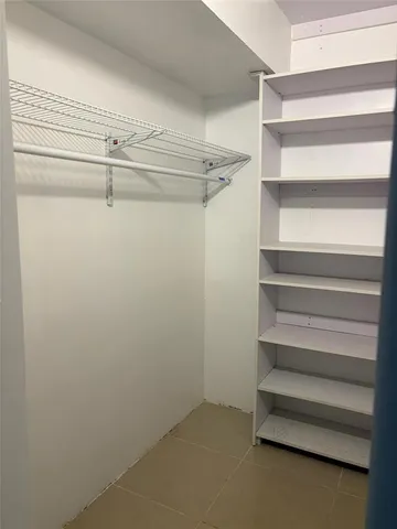 a view of walk in closet with empty racks