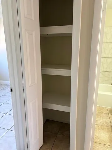 a view of an empty room with closet area