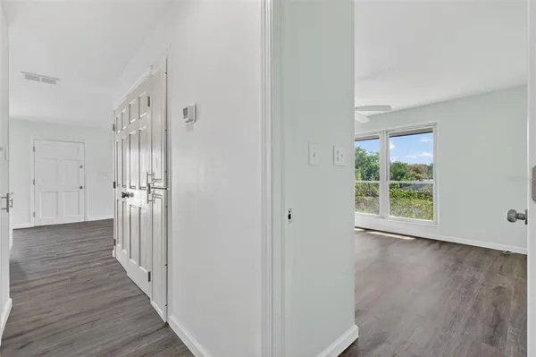 a view of a hallway with wooden floor and a window