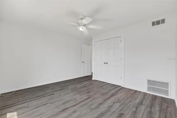 a view of an empty room with wooden floor