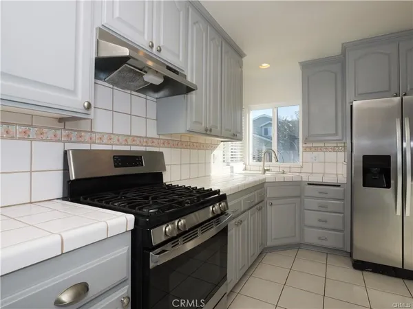 a kitchen with stainless steel appliances granite countertop a stove and a refrigerator
