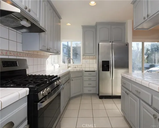 a kitchen with stainless steel appliances granite countertop a stove a refrigerator and a sink