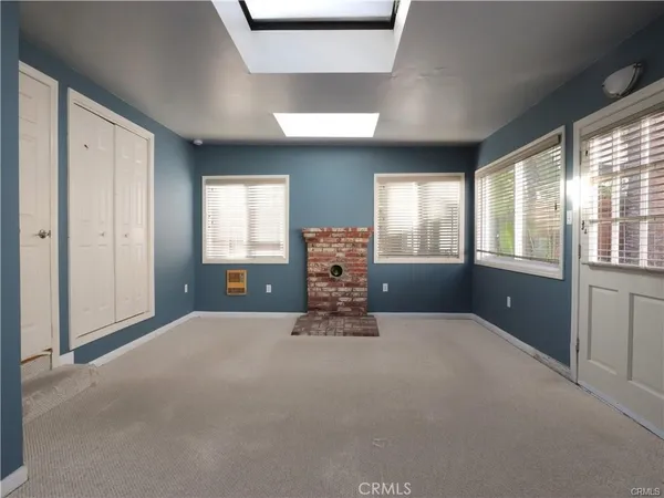 a furnished livingroom with windows and cabinet