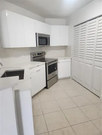 a kitchen with a stove a sink and a microwave