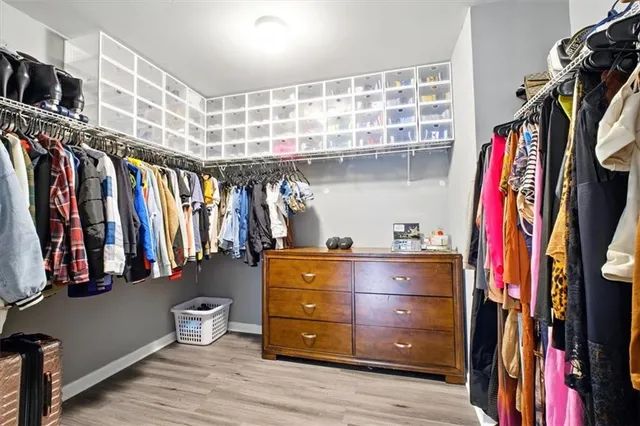a view of walk in closet with clothes and shoes