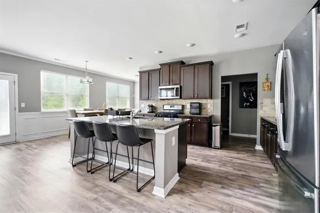 a kitchen with kitchen island granite countertop wooden floors and stainless steel appliances