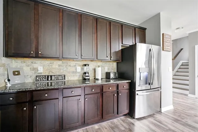 a kitchen with stainless steel appliances granite countertop a refrigerator and a sink