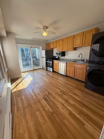a kitchen with stainless steel appliances wooden floor and a refrigerator