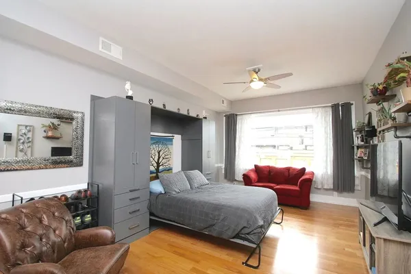 a bedroom with bed couch and window