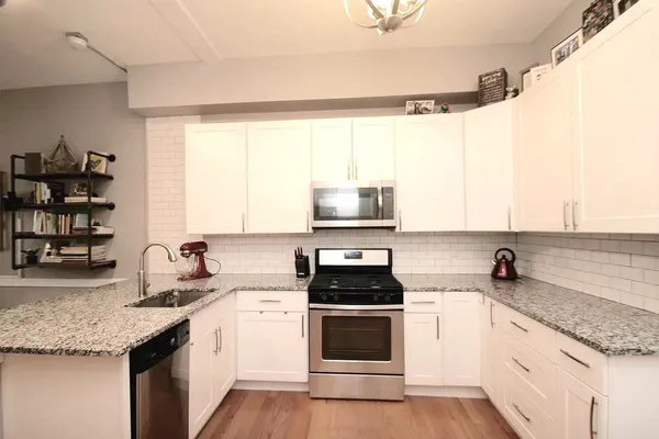 a kitchen with stainless steel appliances granite countertop a sink a stove and a microwave