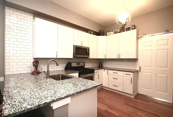 a kitchen with granite countertop kitchen island stainless steel appliances a stove sink and microwave