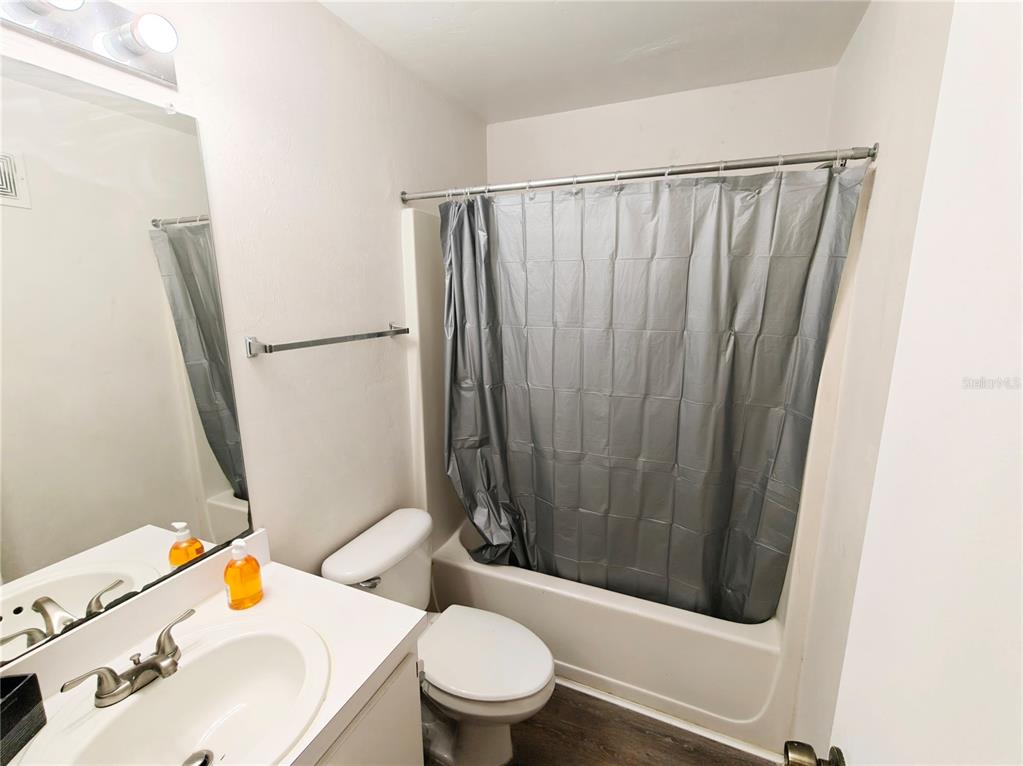 4000 Southwest 23rd Street, Unit 5207 ROOM A Gainesville, FL 32608 - Photo 14 of 17 a bathroom with a sink a toilet a mirror and shower