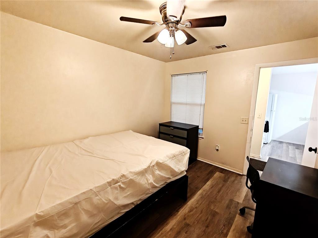4000 Southwest 23rd Street, Unit 5207 ROOM A Gainesville, FL 32608 - Photo 10 of 17 a bedroom with a bed and wooden floor