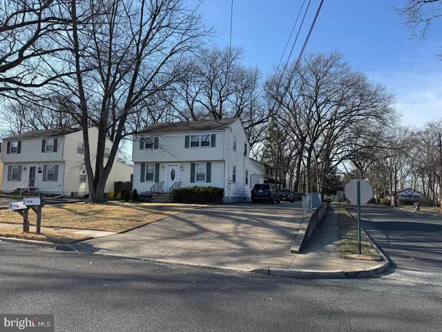 a view of a fountain with brick walls plants and large tree