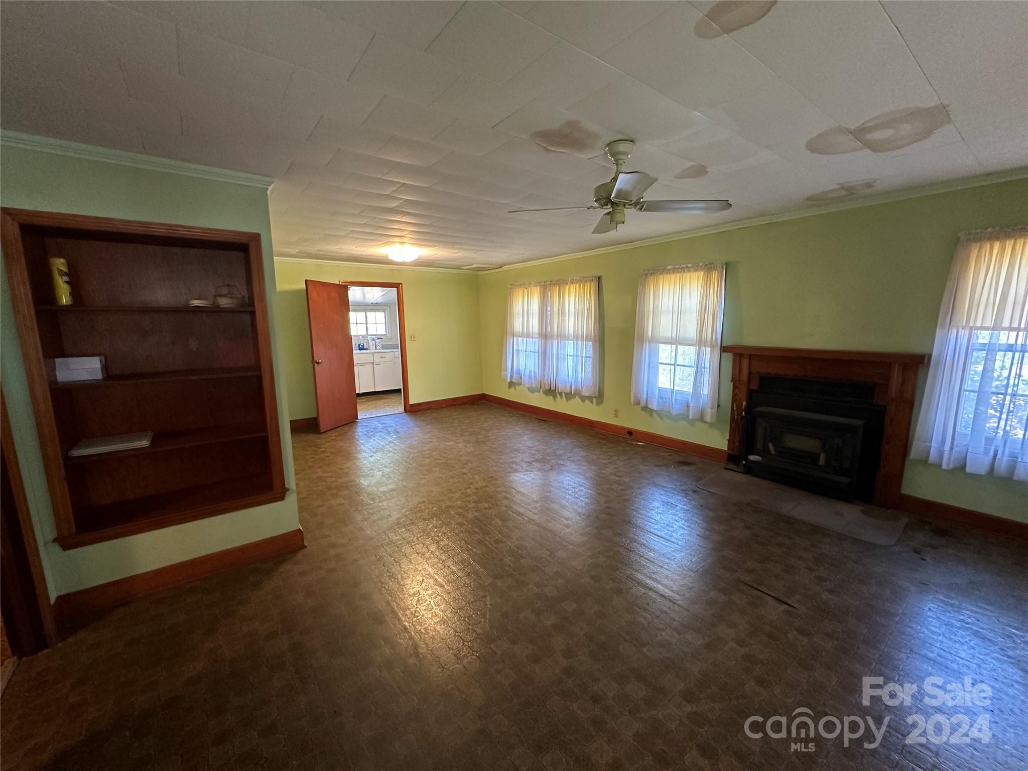 11298 Highway 265 Jefferson, SC 29718 - Photo 11 of 22 an empty room with windows fireplace and a ceiling fan