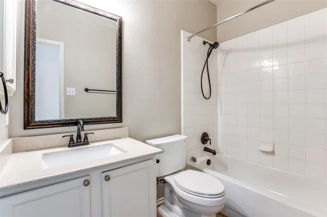 a bathroom with a granite countertop sink a toilet and a mirror