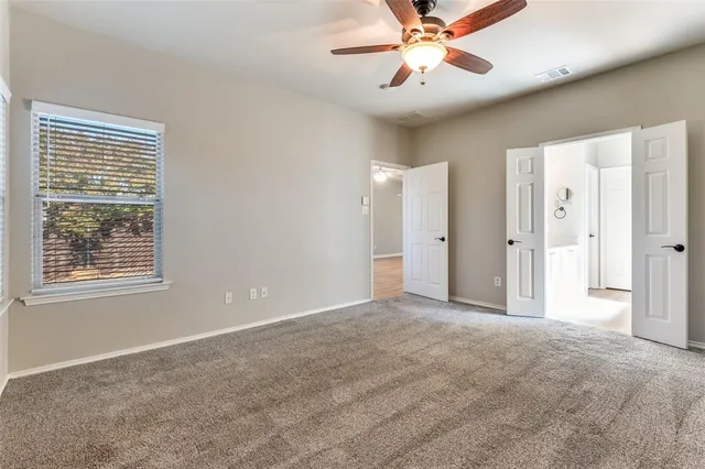 an empty room with closet and a chandelier fan