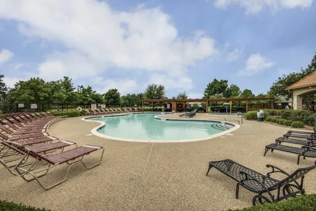 a swimming pool with outdoor seating and barbeque oven