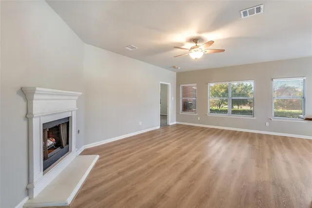 wooden floor fireplace and natural light in empty room