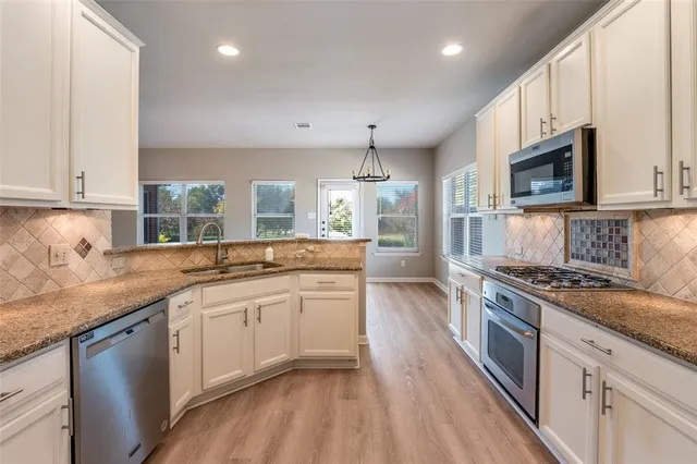 a kitchen with stainless steel appliances granite countertop a sink stove and refrigerator
