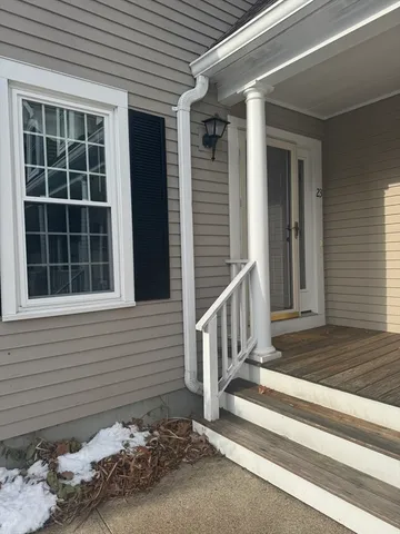 a view of a house with a door and wooden bench
