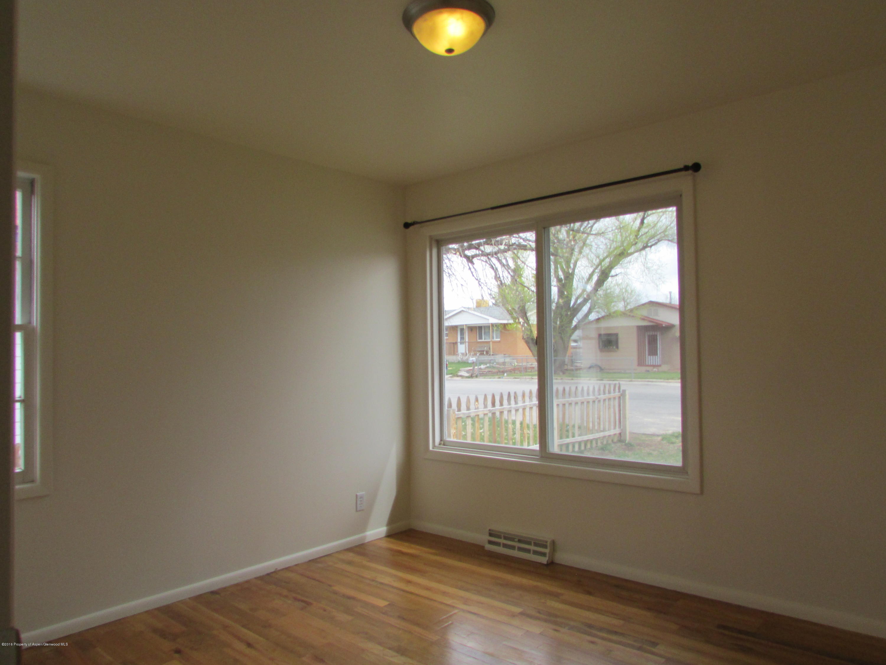 405 Elm Avenue Rifle, CO 81650 - Photo 6 of 14 a view of an empty room with wooden floor and windows
