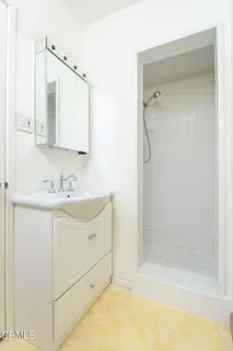 a bathroom with a shower sink vanity and mirror