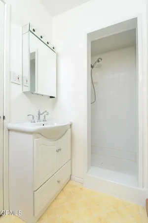 a bathroom with a shower sink vanity and mirror