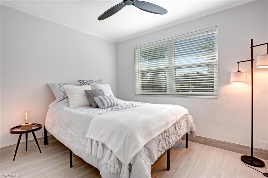982 13th Street North Naples, FL 34102 - Photo 20 of 29 a bedroom with a bed two lamps and a large window