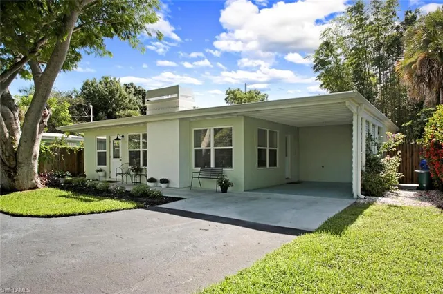 a front view of a house with yard floor and glass top table and chairs