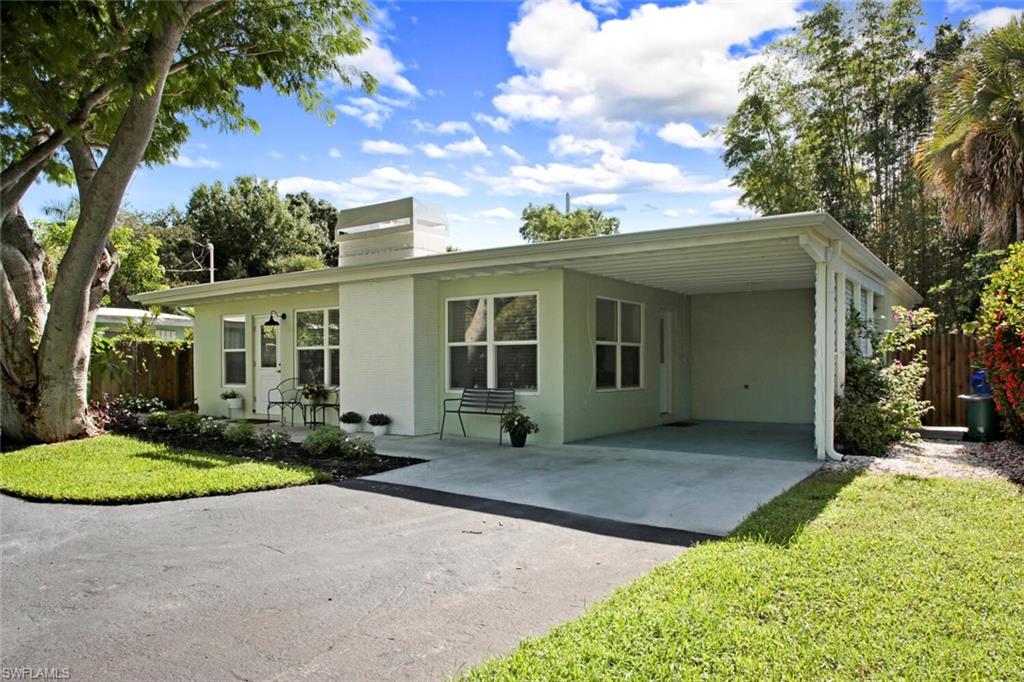 982 13th Street North Naples, FL 34102 - Photo 2 of 29 a front view of a house with yard floor and glass top table and chairs