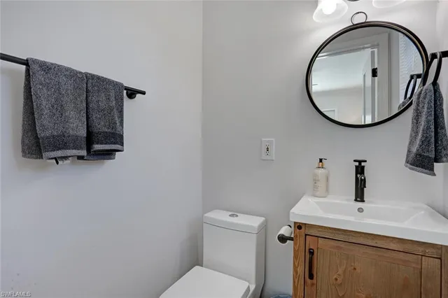 a bathroom with a toilet a sink and mirror