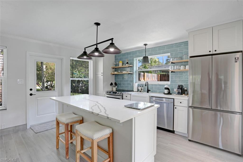 982 13th Street North Naples, FL 34102 - Photo 4 of 29 a kitchen with refrigerator cabinets and wooden floor