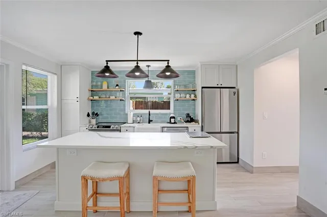 a kitchen with stainless steel appliances a table and chairs in it